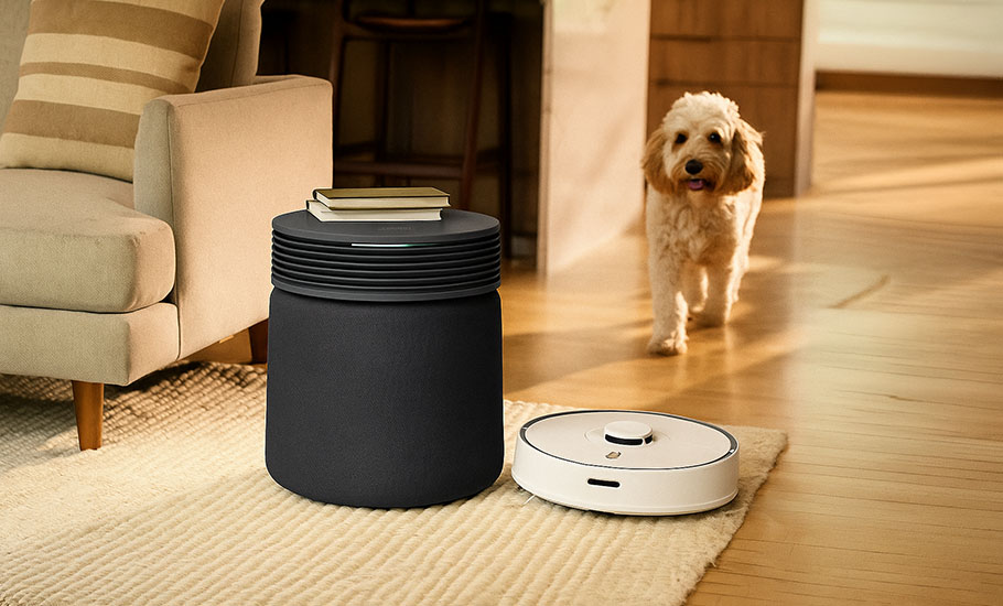 Fiktiv bild med en Blueair Signature Dark luftrenare och en robotdammsugare i ett vardagsrum